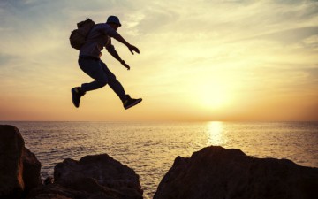 Image of a man jumping from rock to rock