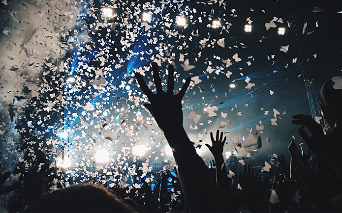 A crowd at a concert with confetti falling from the ceiling