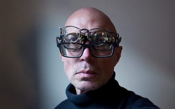 A man wearing multiple pairs of glasses