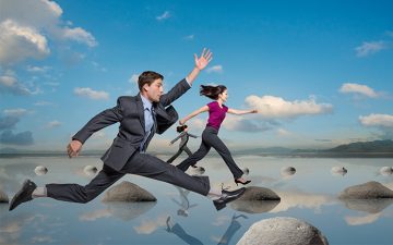 Image of business people leaping on rocks in a lake