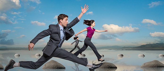 Image of business people leaping on rocks in a lake