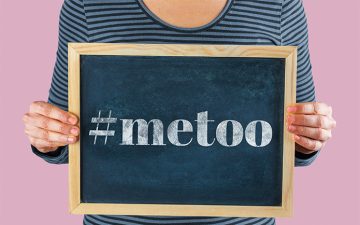 Midsection Of Woman Standing With Blackboard saying #MeToo Against Pink Background