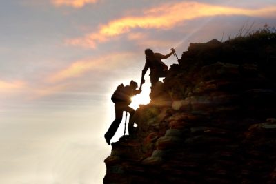 Young Asian Couple Hikers Climbing Up Mountain Cliff Climbing Helps And Team Work Concept